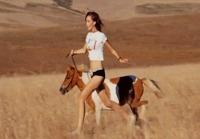 Jättimäisen pitkä nainen juoksuttaa hevosta