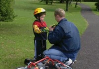 Isä opettaa poikaansa pyöräilemään