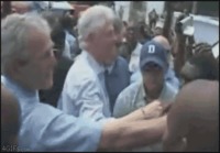 George W. Bush kättelee tummaihoista ja pyyhkii kätensä Bill Clintonin paitaan