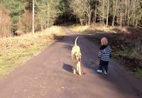 Lapsi ulkoiluttamassa koiraa