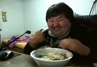 Korealainen mies naureskelee syödessään