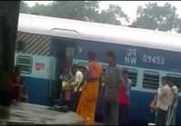 Intialainen nainen pistää ukon nippuun juna-asemalla