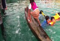 Filippiiniläistyttö tyhjentää kanootin vedestä