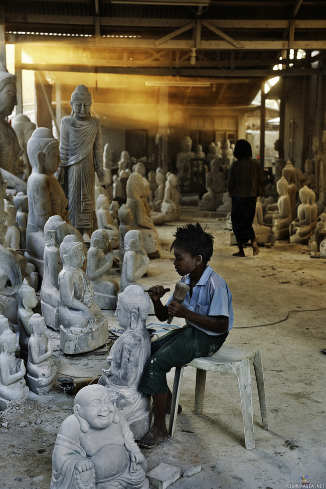 Buddha-patsaiden valmistusta - Poika veistää patsasta käsityönä, joko niitä patsaita valmistetaan ja myydään tai sitten ollaan syömättä -yksinkertaista.